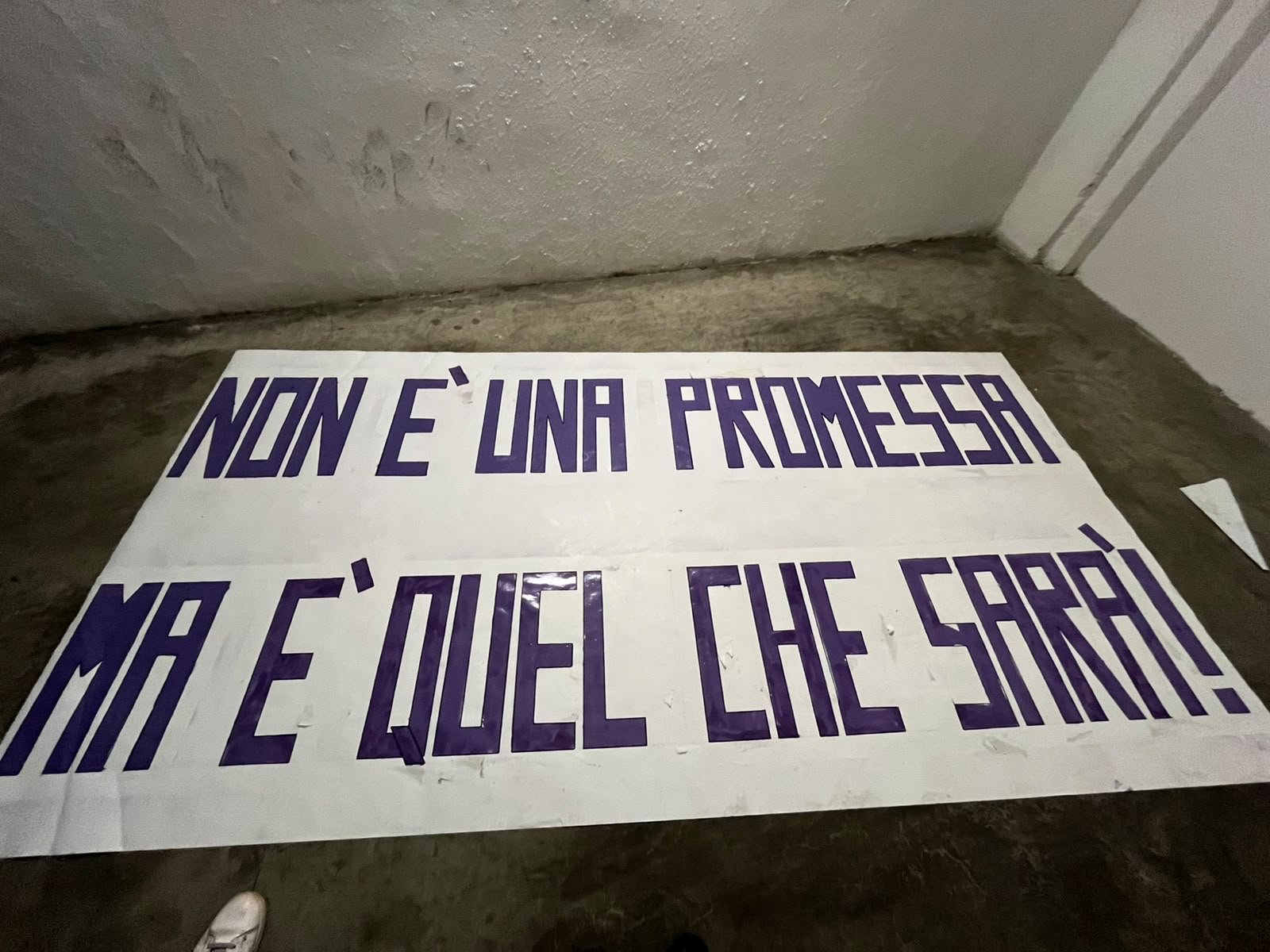 Striscione di Memento con la scritta “Non è una promessa, ma è quel che sarà”